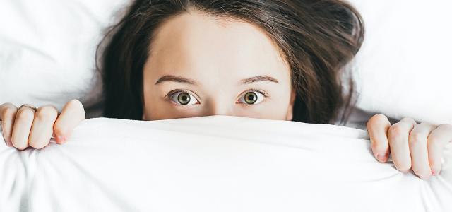 woman covering her face with blanket by Alexandra Gorn courtesy of Unsplash.